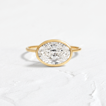 Formation Ring Engagement Ring in Yellow Gold by Melanie Casey shown on a textured white background