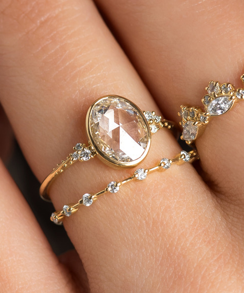 Photo features a Melanie Casey Bezel Engagement Pensive Ring and a Petite Diamond Distance Band.