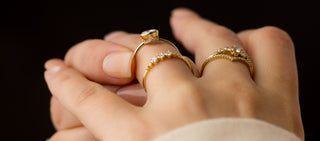 Photo shows a model touching a Caldera Bezel Bezel Engagement Ring on her ring finger and showing off the hidden diamonds underneath.