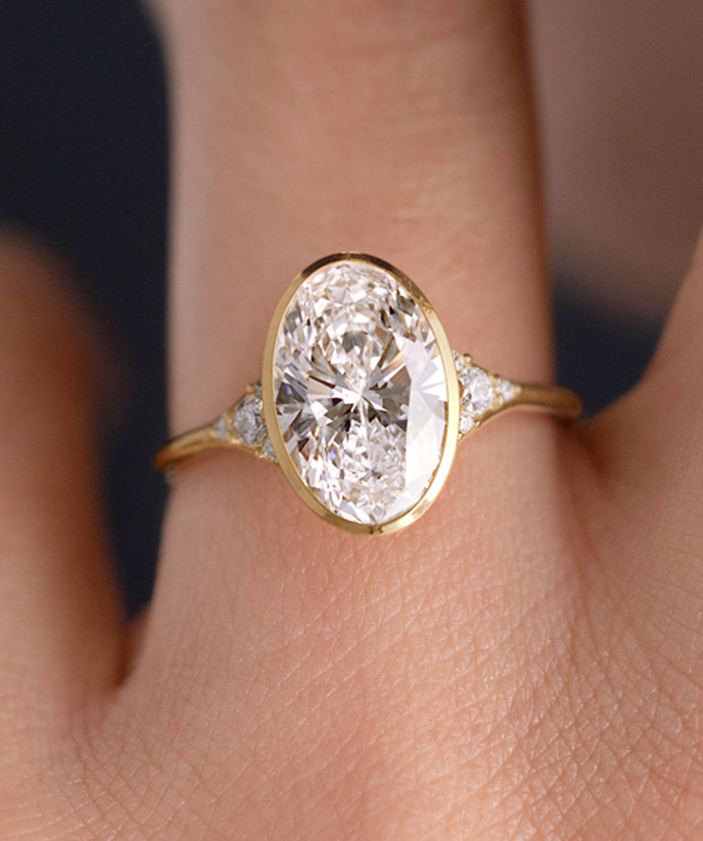 Photo features a 2ct Lady's Slipper Bezel Engagement Ring in Yellow Gold being worn on a model's hand.