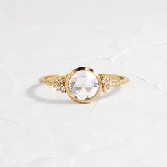 Pensive Ring Rose Cut Engagement Ring in Yellow Gold by Melanie Casey shown on a textured white background