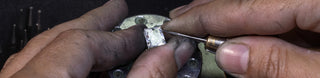 A Melanie Casey Engagement Ring being worked on by a jeweler at their bench.