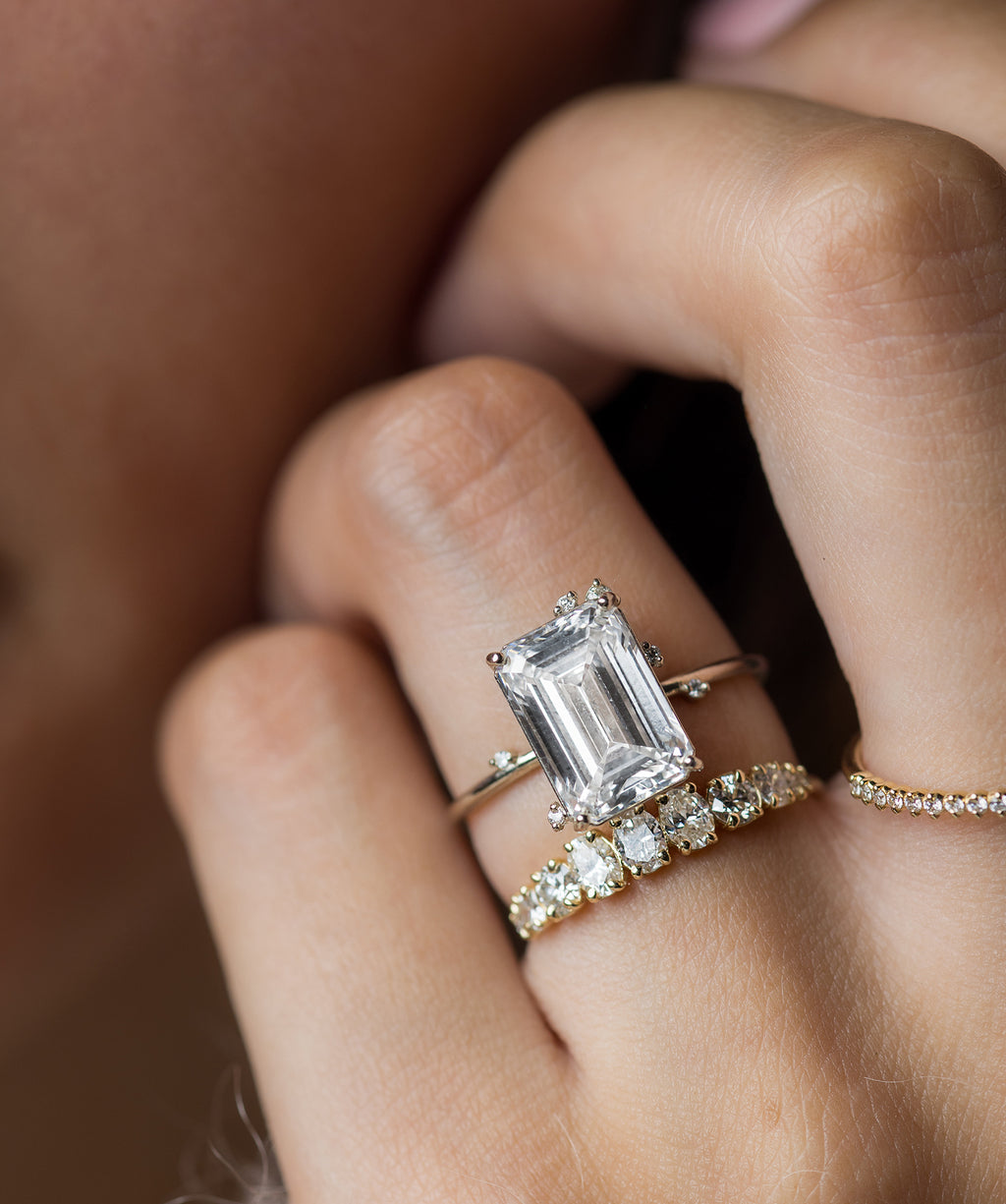 Model shown wearing an Emerald Cut To a Flame Ring in White Gold.